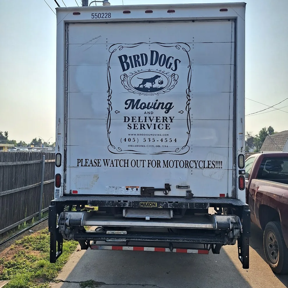 Rear of a Bird Dog box truck with the logo and phone number painted on the door